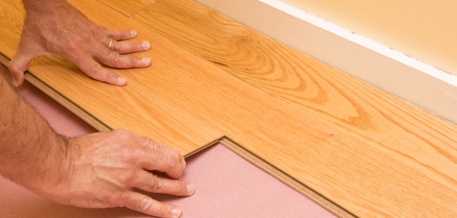 series of engineered hardwood floor being installed by a worker